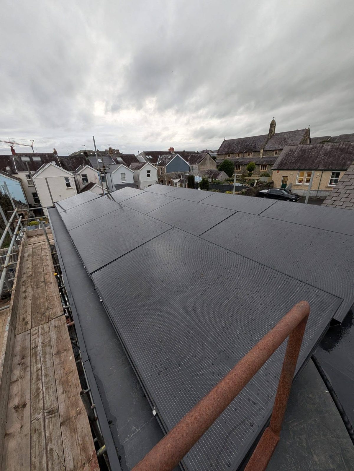 Solar PV array installed on a residential roof with scaffold access